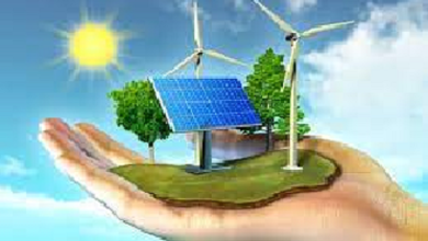 image composition depicting renewable energy, showing solar panel, windmill, green trees, sunlight, on green earth, on open hands